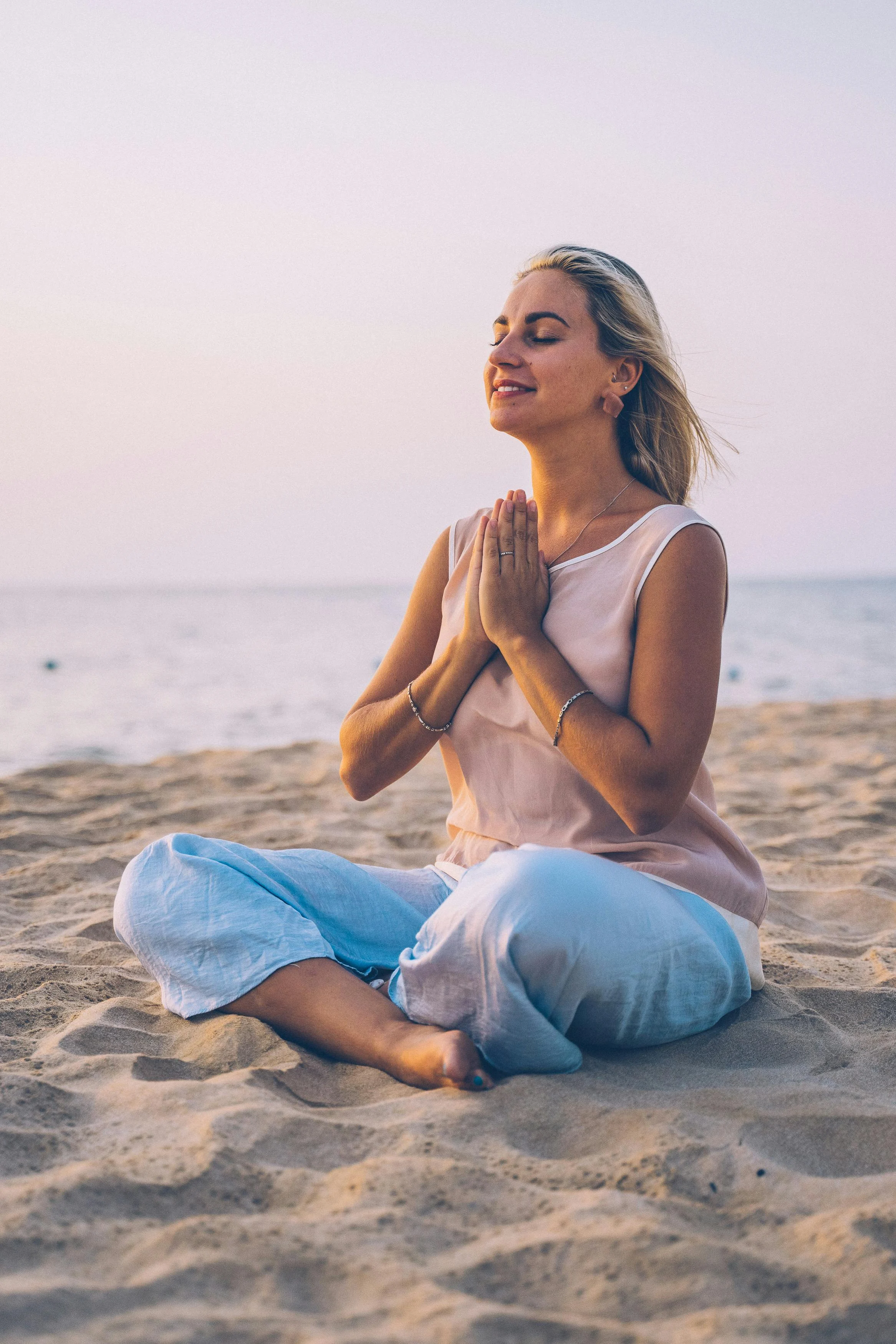Woman meditating on beach